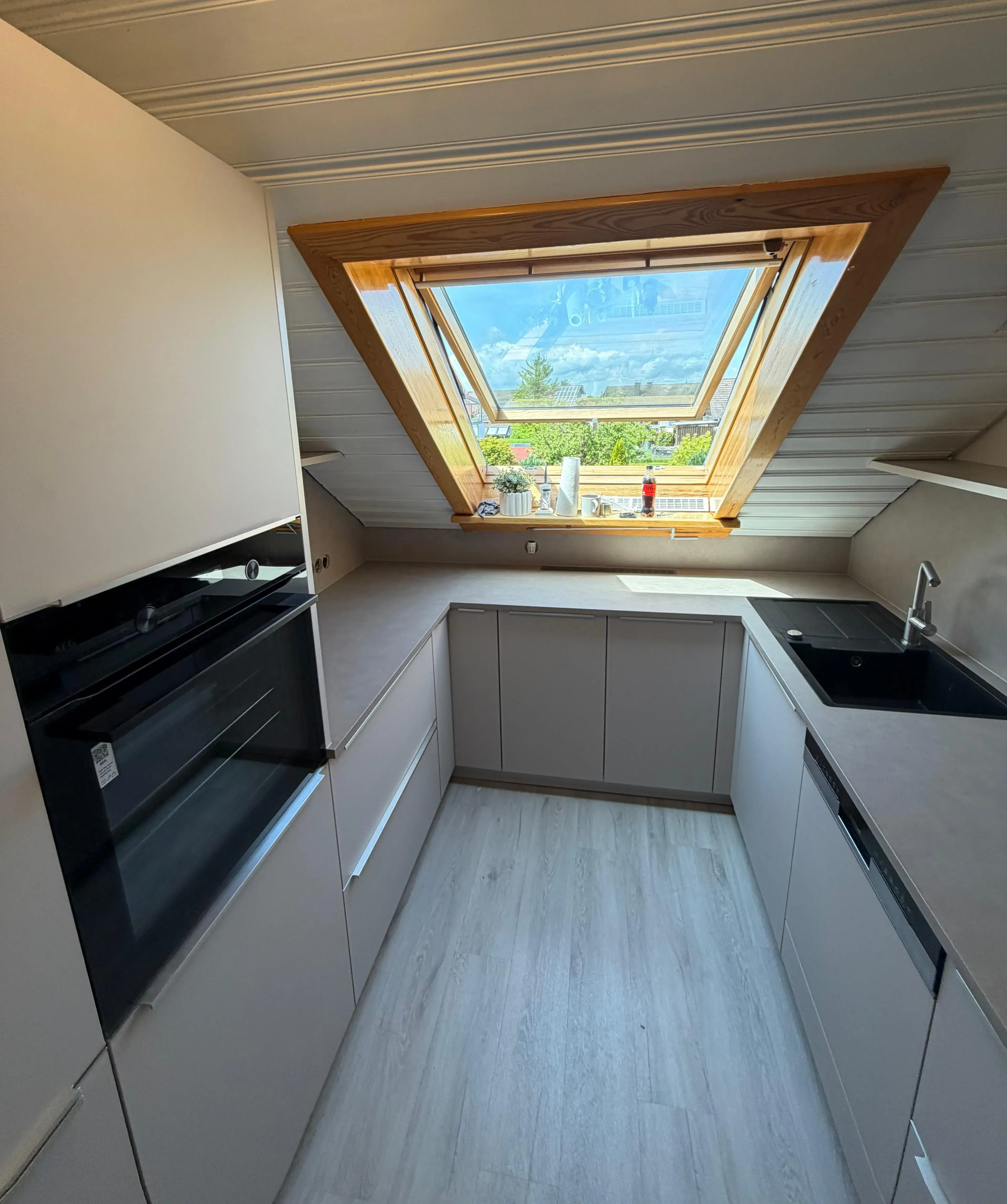 Moderne Dachgeschossküche mit großem Fenster und Bergblick.