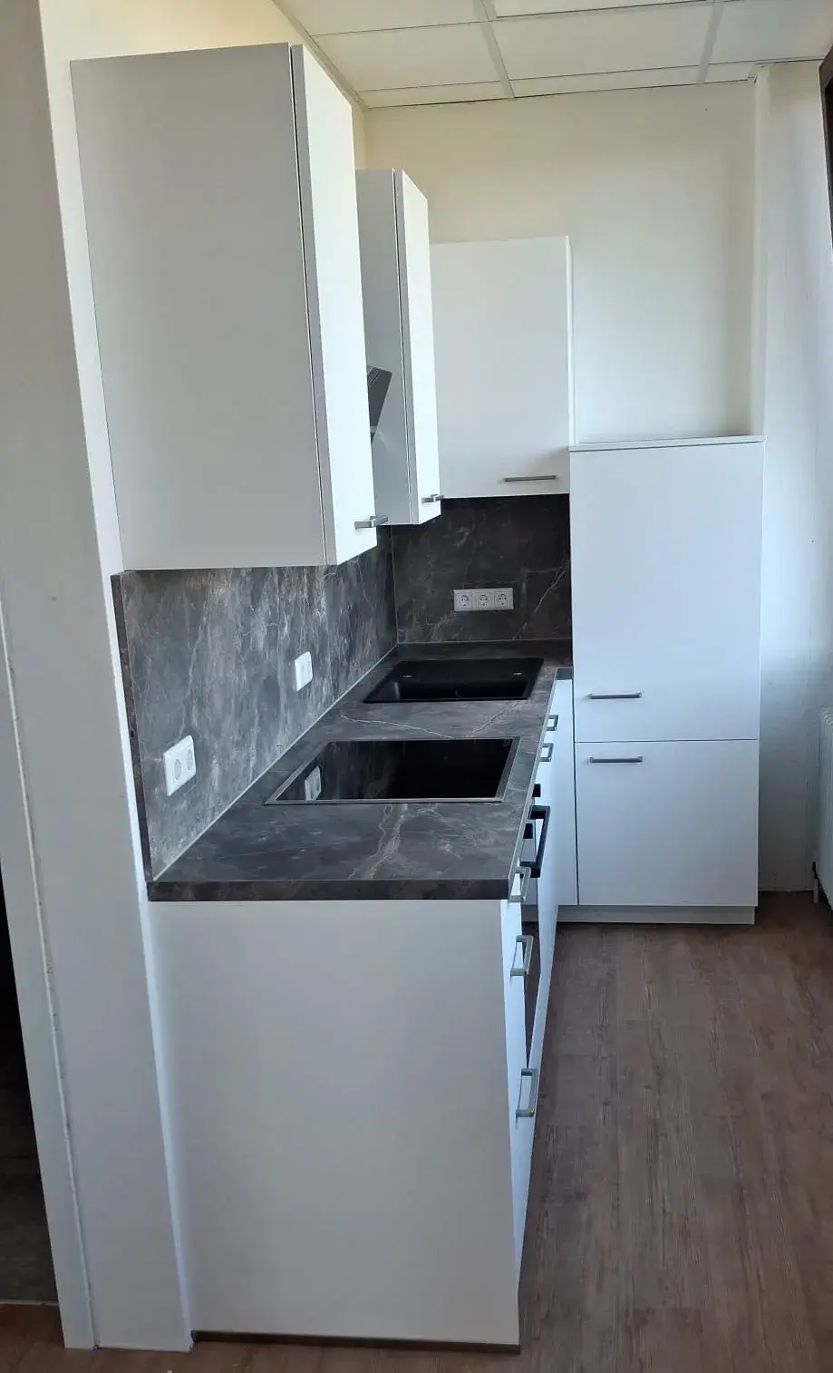 Küchenraum, weiße Küche, Marmor Dekor Arbeitsplatte, Schwarzer Backofen Holzboden